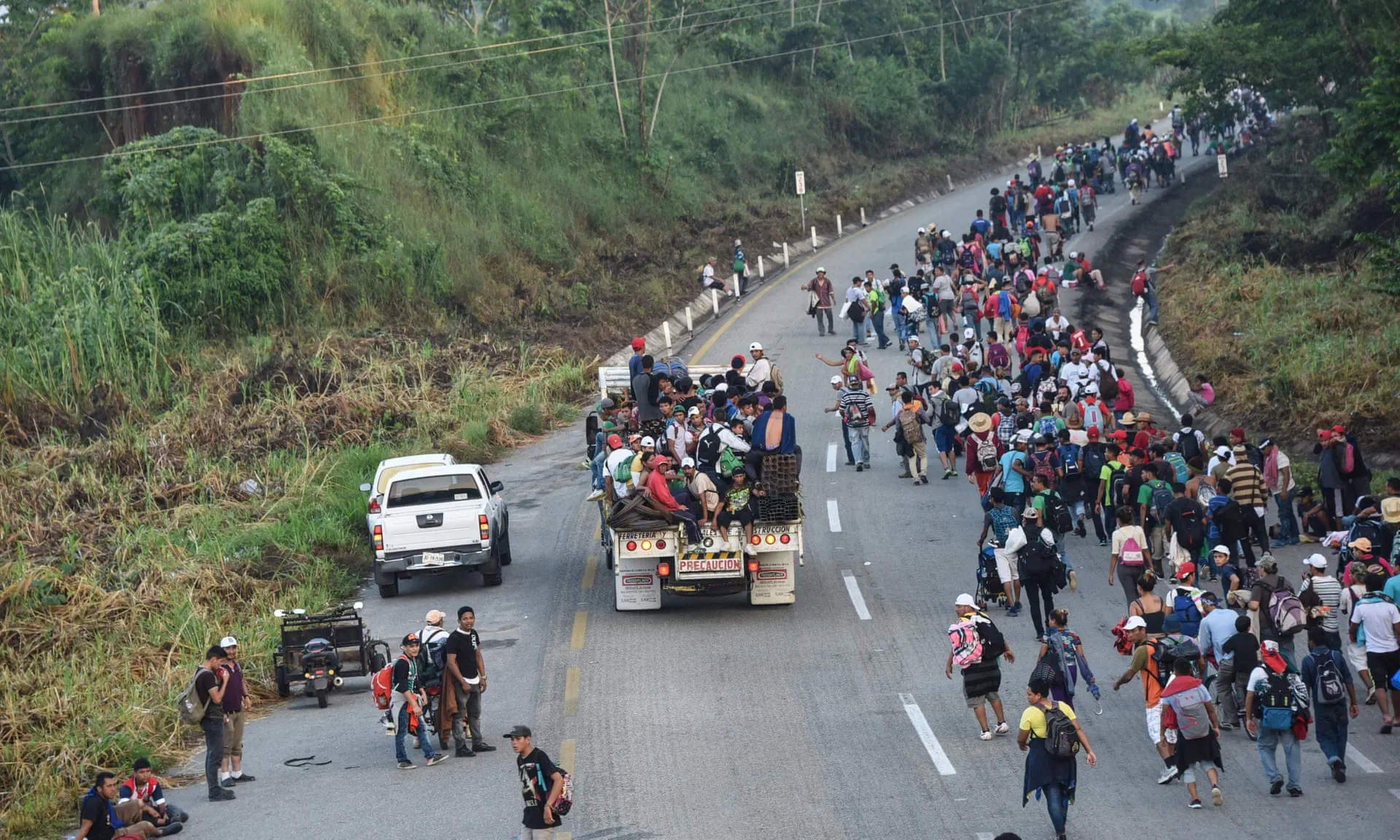 Honduran migrants taking part in a caravan heading to the US, walk alongside the road in Huixtla, Chiapas state, Mexico, on 24 October. Photograph: Johan Ordonez/AFP/Getty Images